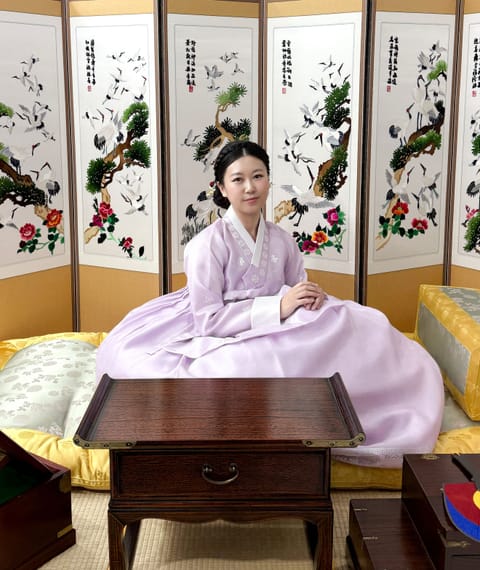 병풍 앞에 한복을 입고 앉은 체험자